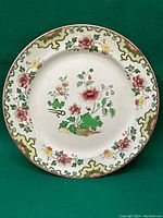 Top view of the full floral plate showing the overall decoration, rim pattern, and condition.