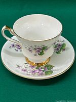 Photo showing the tea cup on the saucer, highlighting the floral pattern and gold rim detailing on both pieces.