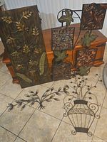 All metal wall hangers displayed on floor and chest, showing variety in shape, size, and design.