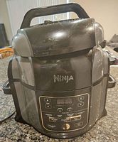 Front view of Ninja Foodi 7-in-1 multi cooker showing control panel, handle, and exterior condition.