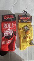 Front view of both socks showing Dungeons & Dragons and Garfield designs with packaging