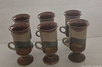 Six vintage Otagiri Irish coffee mugs displayed in a row, showing their shape and glaze.