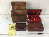 All four vintage boxes including Bayuk Philadelphia Longfellow cigar box, cufflink and tie tack box with accessories, and two other leather boxes.