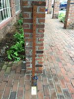 Full view of the 47 inch handmade wooden clamp leaning against a brick column showing length and position of clamps.