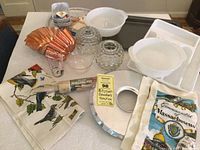 Wide shot of all kitchen items including Fire King casseroles, rolling pin, donut pan, crystal votives, silverware tray, aluminum pans, and kitchen towels.