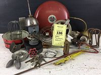 Overview photo showing multiple workshop pieces including metal valves, keys, mechanical parts, and ceramic insulators.