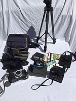 Group shot of all items including Polaroid instant cameras, Canon PowerShot G3 camera with leather case, tripod, camera bags and accessories.