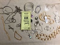 Full view of all jewelry items including silver bangles, chains, rings, earrings, gold wash bracelets and necklaces showing condition and variety.