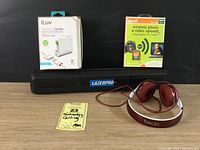 Overall lot photo showing iLuv charger box and item, unopened Eye-Fi card and USB reader package, Laserpro laser level case, and Beats headphones.