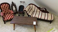 Doll furniture set showing armchair, chaise lounge, wooden coffee table, doll stroller, and mirror.
