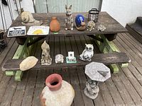Photo showing entire assortment on wooden table including large pot, figurines, and lantern.