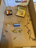 Overall view of lot contents showing multiple earrings, ring, harmonica pendant and necklace
