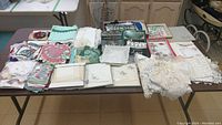 Full display of various lace items, handkerchiefs, and books arranged on table.