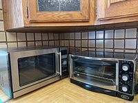 Proctor Silex microwave oven and Oster toaster oven side by side on kitchen counter