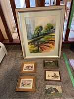 Main large watercolor painting with a rural landscape showing trees, pathway, and fence, framed.