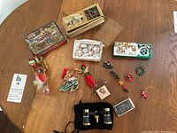 Lot overview showing vintage lighter, miniature dish set, playing cards, musical cards, small ornaments, and opera glasses.