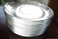 Stacked set of four clear glass plates showing their profile and thickness.