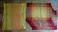 Two stacks of woven placemats showing color and pattern differences between the Finlayson and Tampella sets.