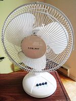 Front view of the white Airworks fan displaying the protective wire cage and Airworks logo on the center hub.