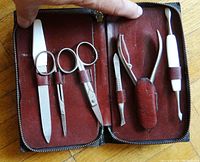 Top-down view of the open antique leather manicure kit showing the six manicure tools securely held in leather loops inside brown suede interior.