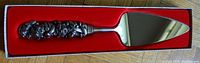 Full view of cake serving blade in original red velvet-lined box showing metal blade and ornate pewter handle.
