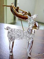 Right-side perspective of glass reindeer showing intricate curled glass body design, smooth legs, and antlers with gold hanging string.