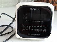 Front view showing Sony branding, digital display, and FM/AM radio frequency markings.