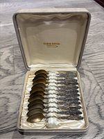 Full set of 12 spoons seated in original Ryrie Bros. case with hinged lid open