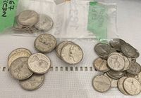 Assorted quarters and dimes in plastic bags and loose on surface