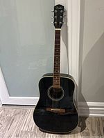 Full body front of black Fender acoustic guitar showing glossy finish and shape.