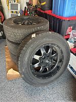 Three tires stacked with one leaning, showing overall set and rim design