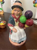 Front view of Royal Doulton Balloon Girl figurine depicting a girl holding colorful balloons.