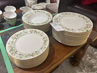 Four stacks of flat plates and one stack of soup bowls, all in Clairmont floral pattern with gold trim.