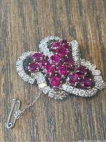 Front view showing ruby cluster and surrounding diamond loops.