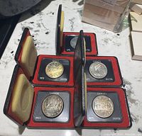 All five 1972 Canadian silver dollars in open red velour-lined flip cases displayed on a surface
