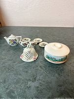 Additional decorative porcelain trinkets including lattice-domed basket and round lidded container