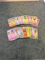 Two stacks of assorted modern Pokemon cards showing variety of characters and types.