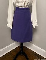Front view of vintage 1970s Rouie Petites purple wool skirt on mannequin showing A-line shape and waistband.