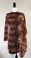 Front side of the vintage 1970s brown midi dress showing asymmetrical sleeves and groovy flower power pattern.