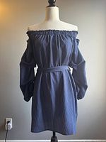 Front view of the women's off-shoulder navy blue and white striped dress on a mannequin, showing elastic neckline, long balloon sleeves, and cinched waist belt.