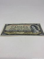 Clear full view of the front of the 1954 Canadian twenty dollar bill showing detailed design and portrait of Queen Elizabeth II.