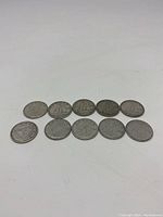 Ten Canadian silver dimes laid in two rows showing front (reverse) Bluenose schooner design and some dates visible.