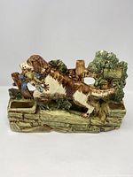 Front view of the McCoy USA hunting dog planter showing the dog with bird in mouth and a 'No Hunting' sign in the greenery behind.