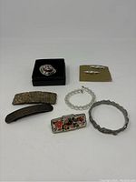 Full view of lot showing boxed purse hanger, bracelets, hair clips, and lipstick caddy