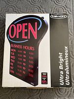 Photo of Newon Ultra Bright Open sign packaging showing front with image and business hours display on the sign, includes brand and product line.