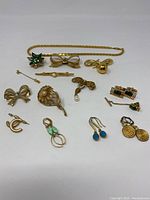 Full lot photo showing all costume jewelry items on a white background including necklace, pins, earrings, brooches, and cufflinks.
