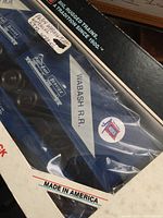 Close-up photo showing Lionel Wabash R.R. flat car with trailer inside its box packaging, with Wabash logo and markings visible on the side of the flat car.