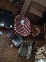 Top-down view of six Longaberger baskets placed on wooden floor, showing various sizes, shapes and liners