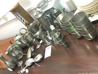 Image showing the full collection of pewter items: pitchers, teapot, mugs, sugar and creamer, multiple cups and shot glasses, vase, and spoon.