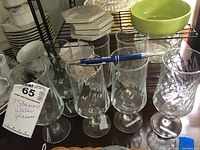 Seven clear glass water glasses with swirl pattern on bowl and stems